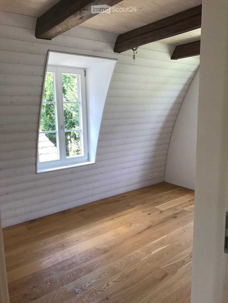 empty room, wooden flooring, white walls, small window, wooden beams