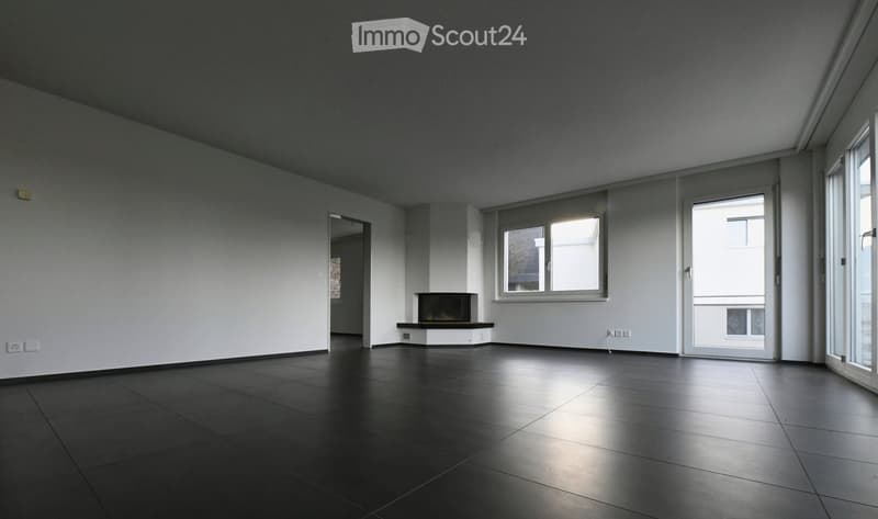 Large empty room, black floor, white walls, windows, fireplace
