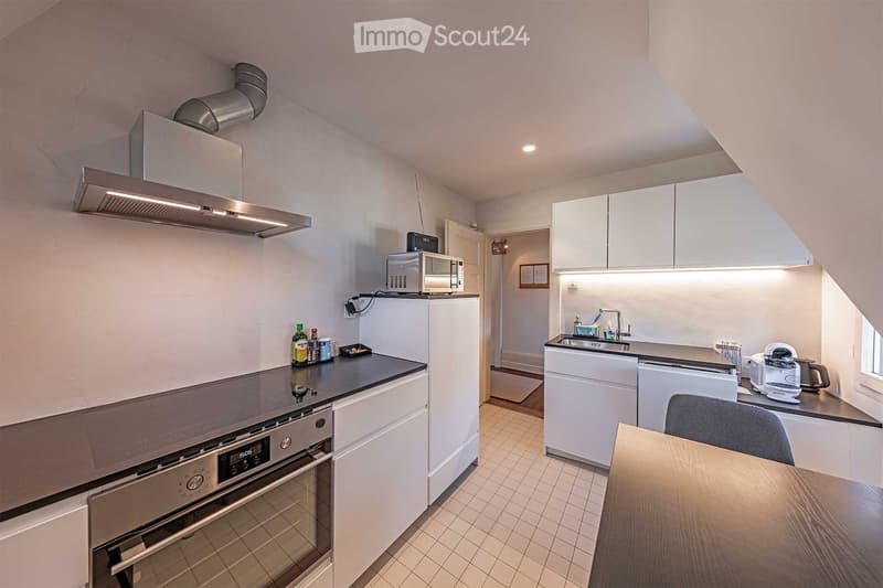 modern kitchen with granite countertops, stainless steel appliances, white cabinetry, central island with seating, under cabinet lighting, wine cooler, tile flooring, wine glasses