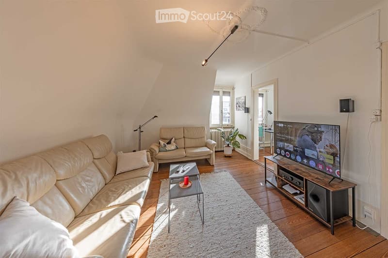 living room, beige couches, white rug, coffee table, television, wooden floors