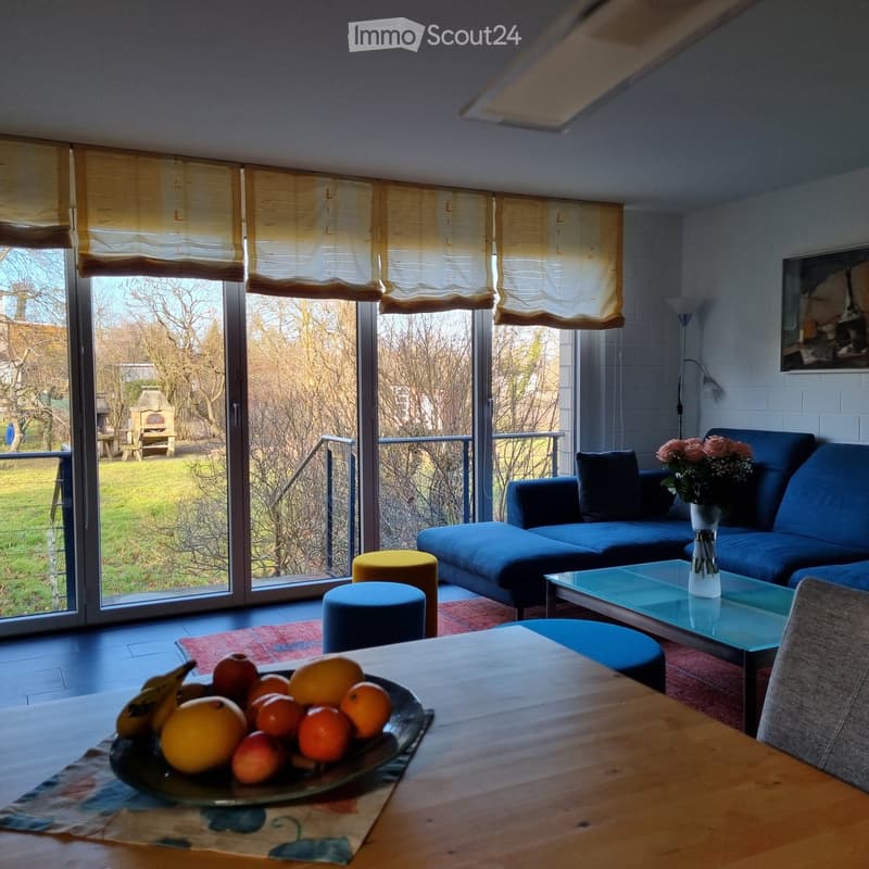 large windows, balcony, blue sofa, coffee table, flowers, fruit bowl, rug, lamp