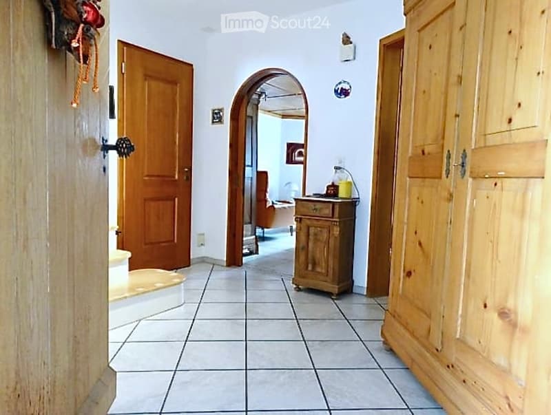 tiled floor, wooden doors, wooden cabinet, archway, white walls, small table, yellow container