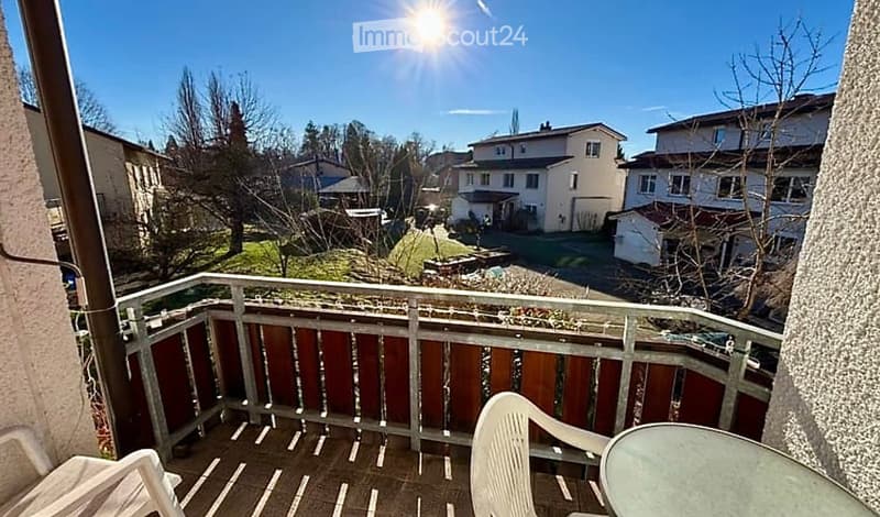 balcony with wooden railing, white chairs, round table, view of the neighborhood