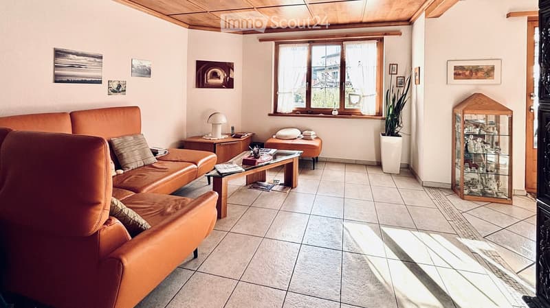 large orange sofa, coffee table, lamp, window, tiled floor, plant