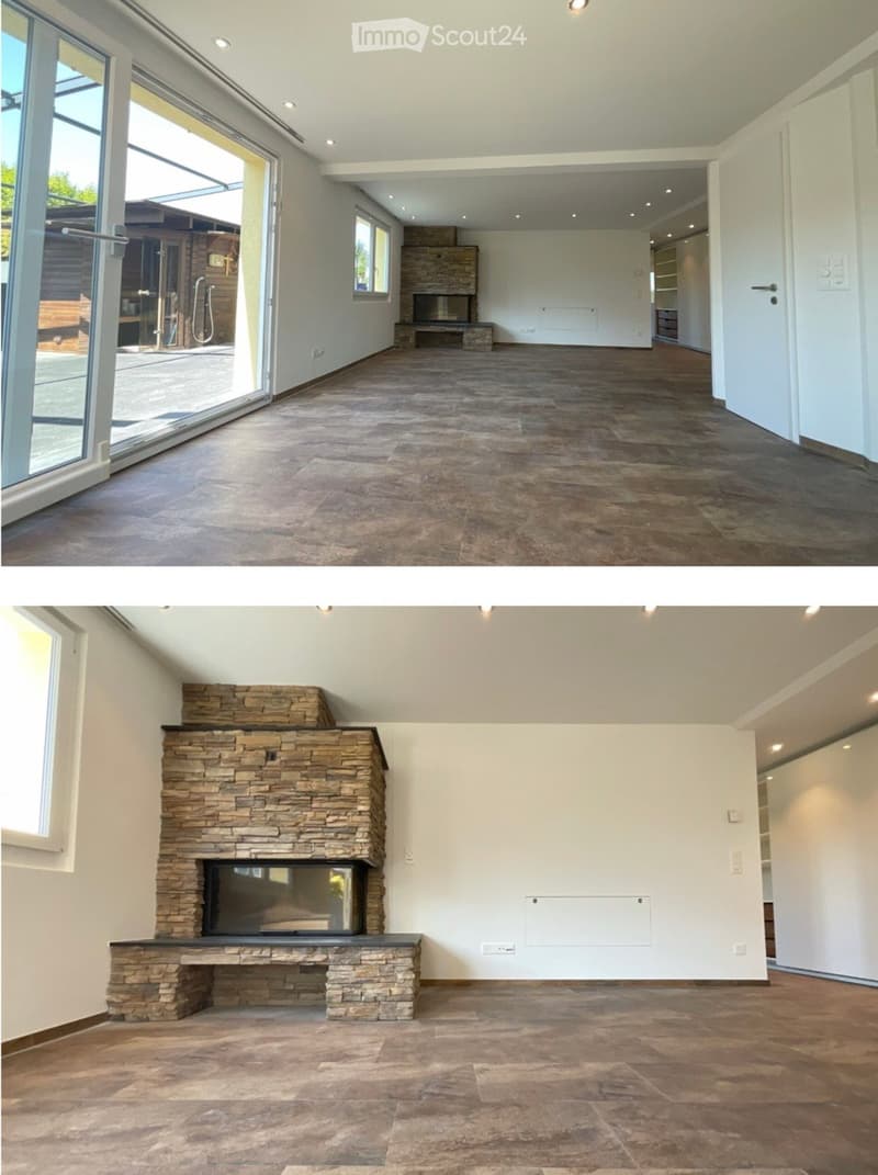 Empty room with tiled floor, large windows, and a stone fireplace.