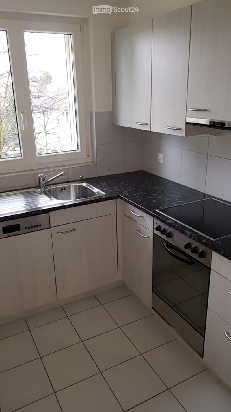 Modern kitchen with white cabinets, granite countertops, stainless steel sink, oven, and dishwasher.