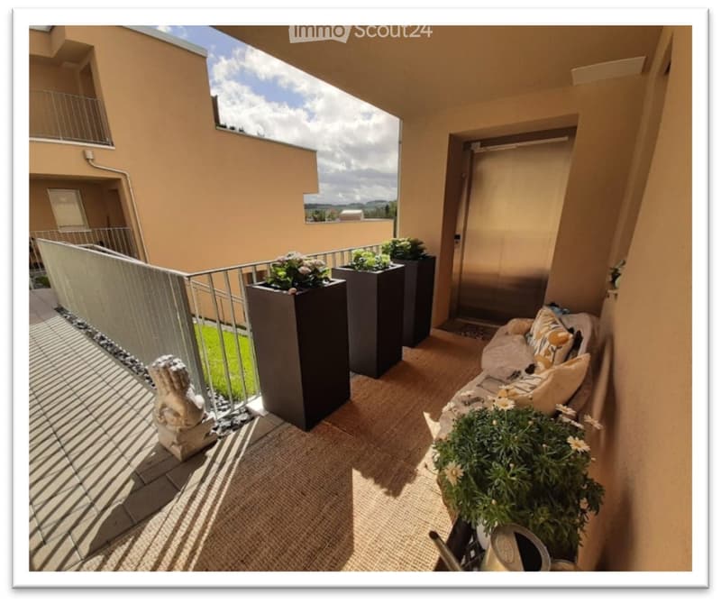 Balcony with modern furniture, potted plants, and a scenic view of the surrounding area.