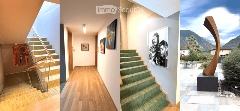 Modern hallway with wooden flooring, green carpeted stairs, glass railing, and framed artwork on walls.