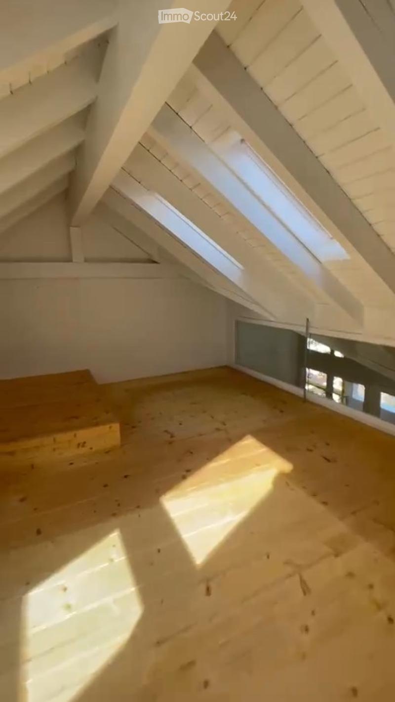 Unfurnished Room. Empty attic space with wooden floor, white wooden beams, skylights, and a small window. No furniture or equipment present.