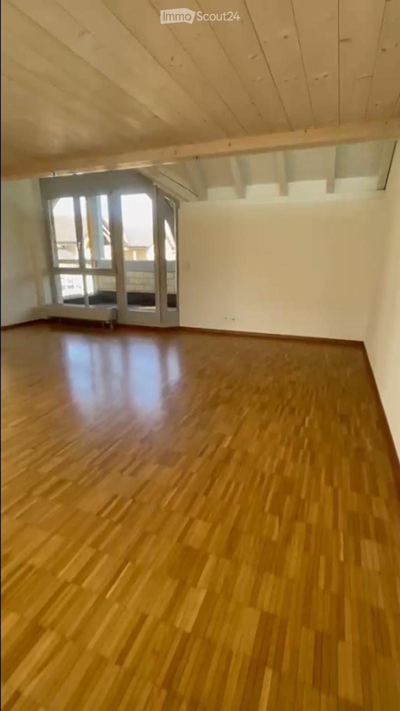 Unfurnished Room. Empty room with wooden flooring and white walls, featuring large windows and a sliding door leading to a balcony.