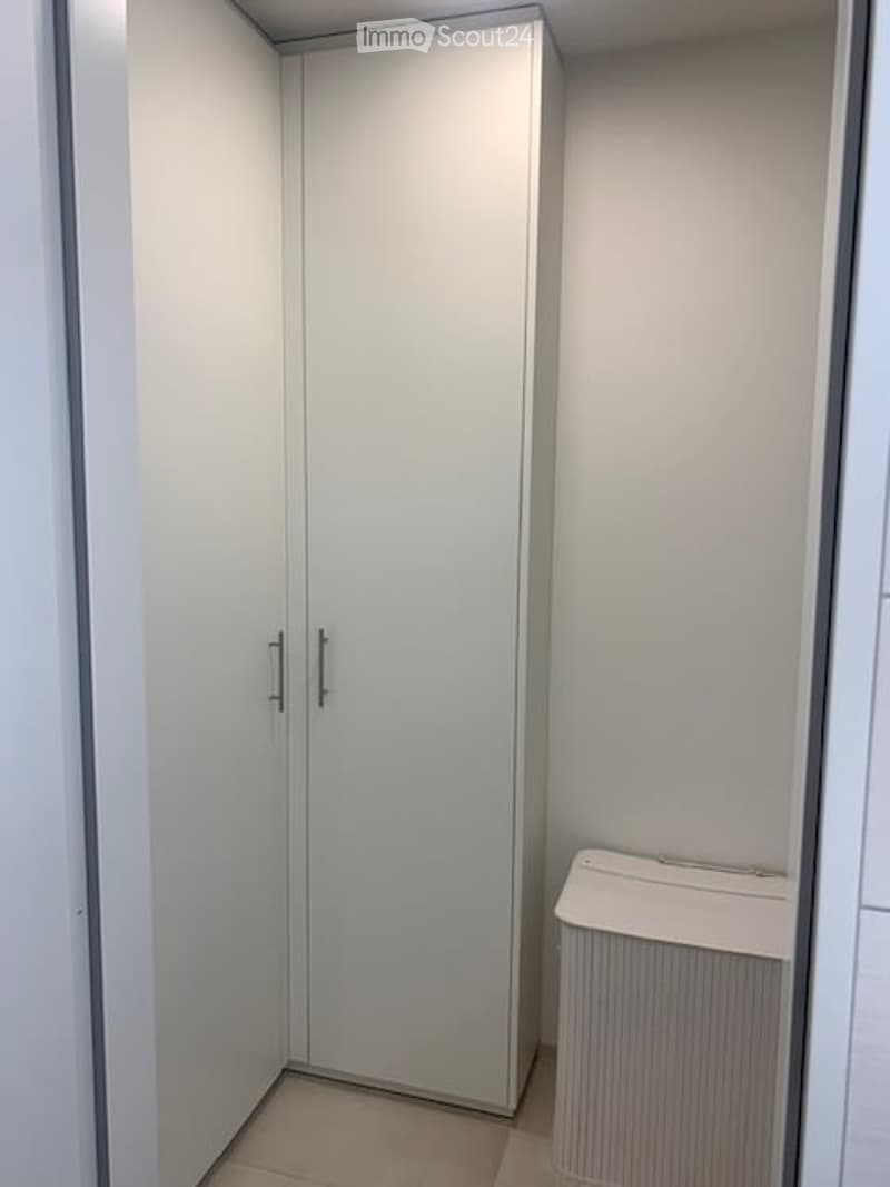 Empty room with white walls, a built-in wardrobe, and a radiator. No furniture or personal items are present.