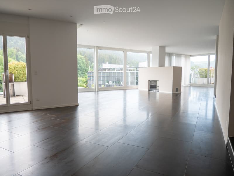 Empty room with large windows, polished tile floor, and a fireplace. No furniture or equipment present.