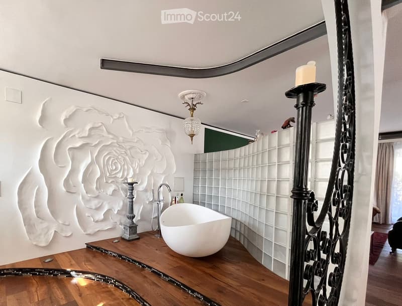Modern bathroom with a freestanding bathtub, ornate candle holder, and decorative wall art featuring a rose design.