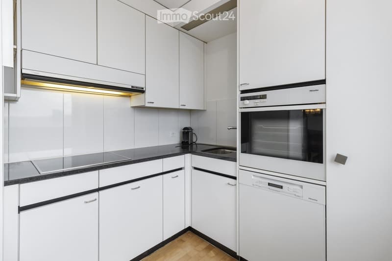 Kitchen. Modern kitchen with white cabinets, black countertops, and stainless steel appliances.