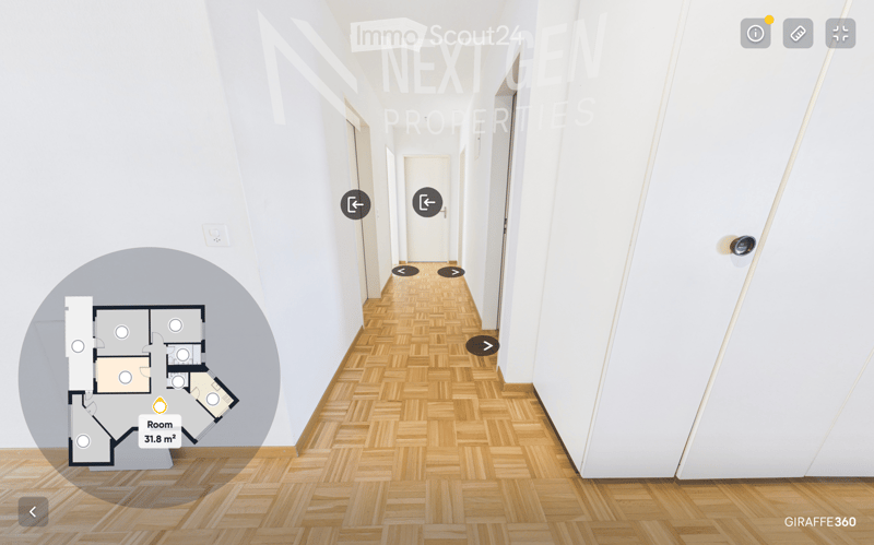 A clean, well-lit hallway with wooden flooring and white walls, featuring several doors and a floor plan overlay in the foreground.