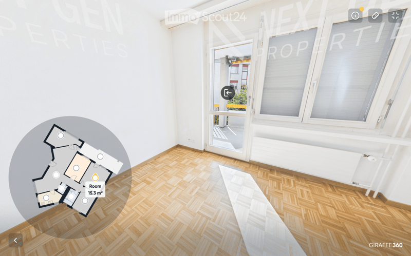 Empty room with wooden herringbone flooring, white walls, large windows, and a sliding glass door leading to a balcony.