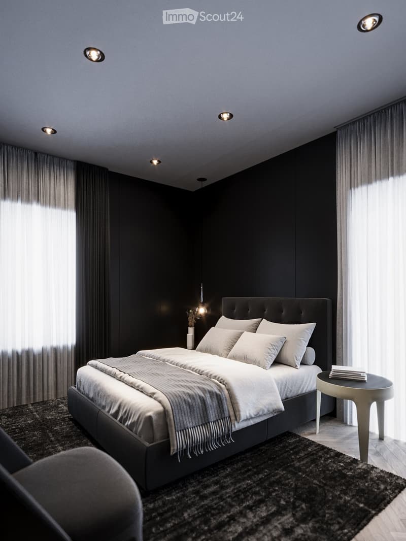 a bedroom with black walls, white bedding, a gray blanket, and a gray chair