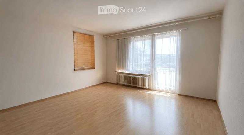 Empty room with wooden flooring, white walls, and large windows with blinds. No furniture or equipment present.