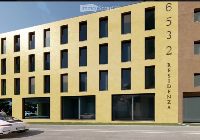 Modern multi-story residential building with yellow facade, large windows, and numbered floors from 1 to 6. A white sports car is parked in front.