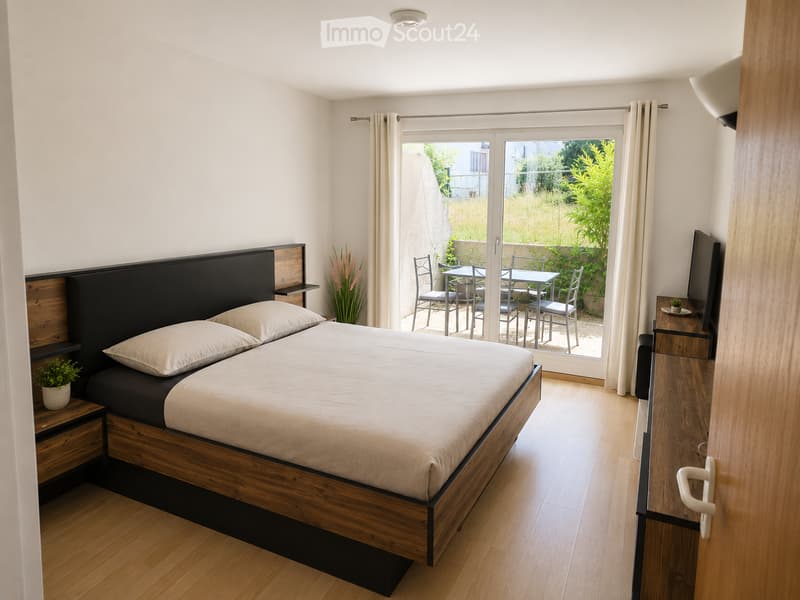 A modern bedroom with a wooden bed, nightstands, a TV, and a sliding glass door leading to a small outdoor seating area.
