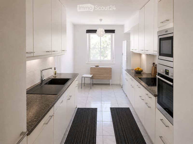 Modern kitchen with white cabinets, dark countertops, stainless steel appliances, and a window above the sink.