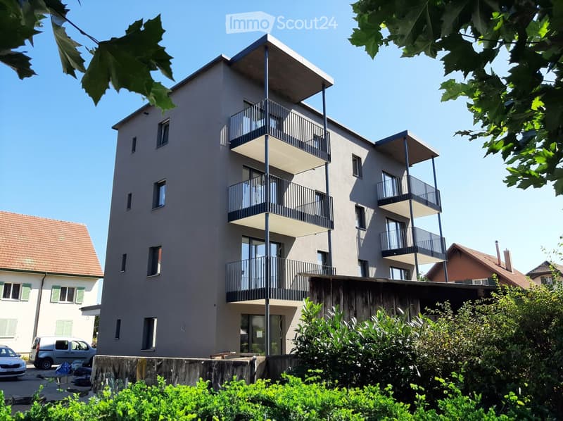 3-story residential building, gray exterior, multiple balconies, modern design, surrounded by greenery