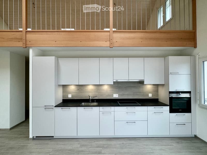 modern kitchen with white cabinets, black countertops, stainless steel sink, gas stove, oven, wooden balcony