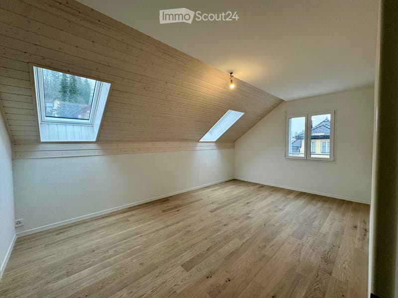 empty room, wooden floor, white walls, wooden ceiling, two skylights, small light fixture