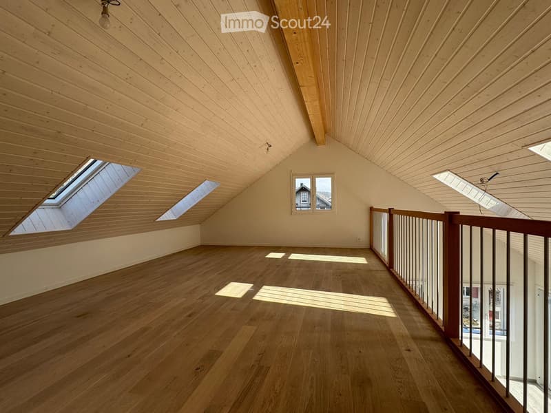 empty attic room, wooden floor, wooden ceiling, skylights, wooden railing
