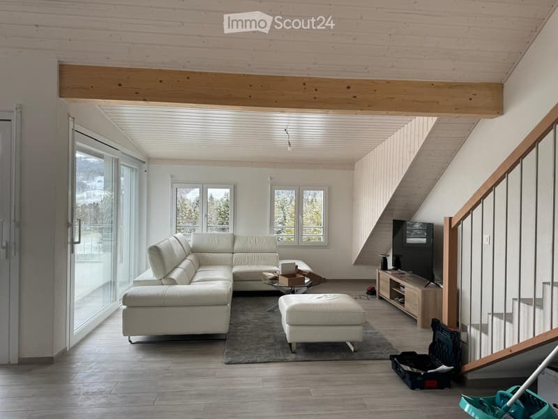 modern living room with white leather sofa, glass coffee table, TV, carpet, wooden floor, large windows, wooden beam