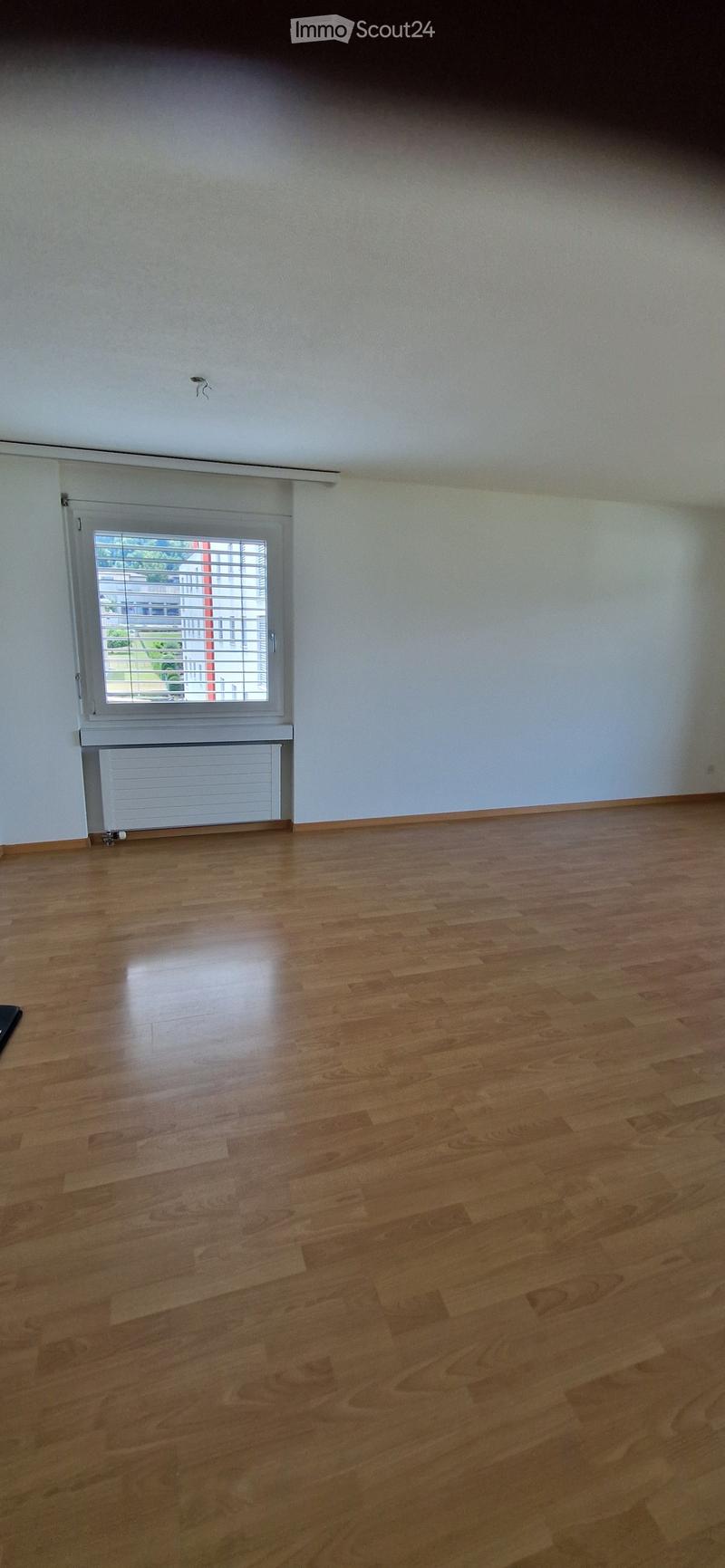 Empty room with wooden flooring, white walls, and a window with blinds. No furniture or equipment is present.