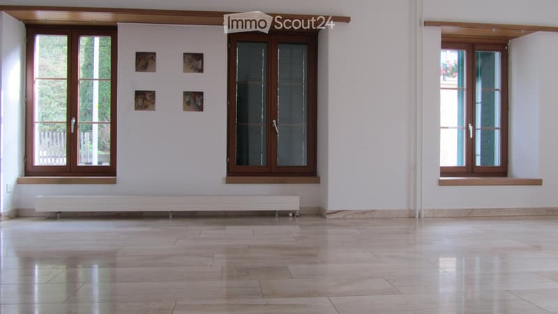 Unfurnished Room. Empty room with light-colored tiled floor, white walls, large windows with wooden frames, and a white radiator under one window. No furniture or equipment present.