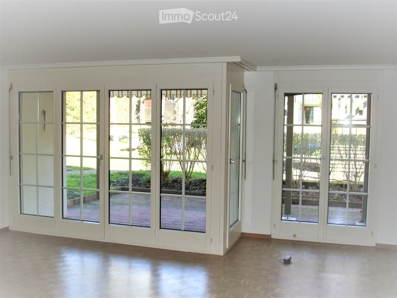 large glass doors, wooden floor, white walls, garden view
