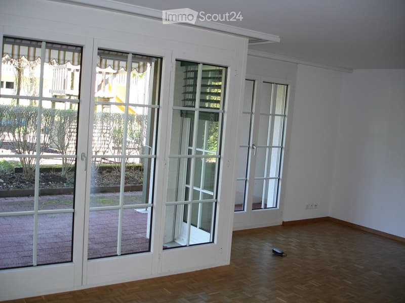 large glass doors, wooden floor, white walls, balcony
