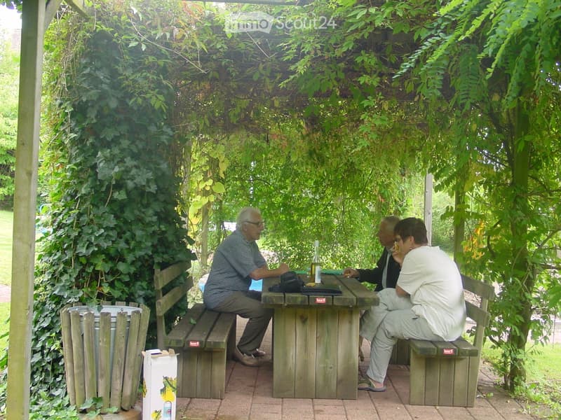 wooden bench, wooden table, people sitting, bottle, box, trash can, green plants