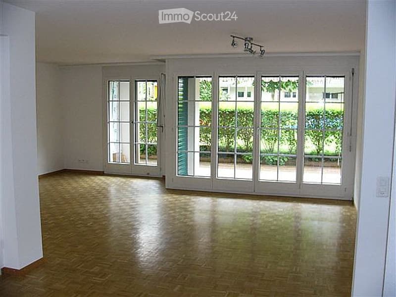 empty room, wooden floor, white walls, large glass doors, balcony