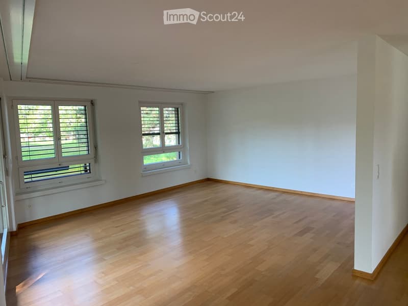 Empty room with wooden flooring, white walls, and two windows with blinds. No furniture or equipment present.
