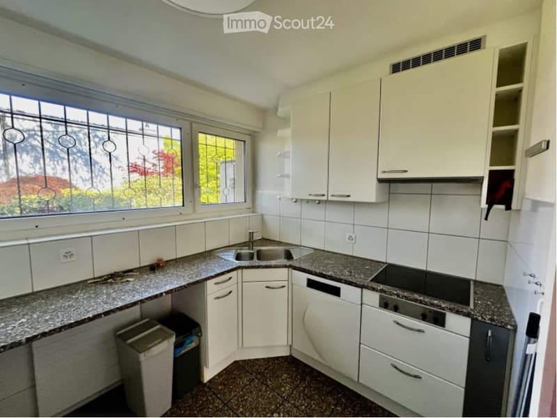 Modern kitchen with white cabinets, granite countertops, stainless steel sink, and appliances.