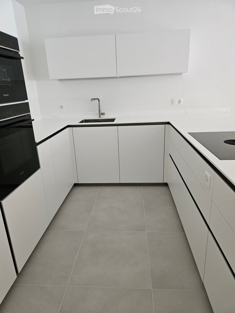 corner room, gray tiles, white cabinets, countertop, sink, electrical outlets