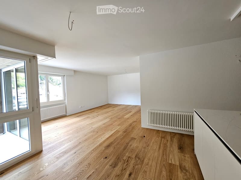empty room, hardwood floors, large windows, two white radiators, sliding door with balcony