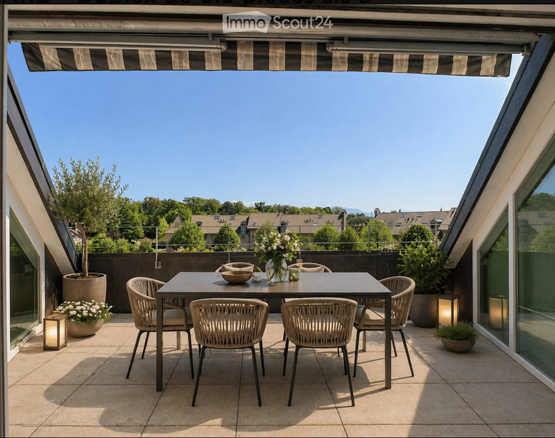 A modern rooftop terrace with a dining table, six chairs, a vase with flowers, and potted plants, shaded by a retractable awning.