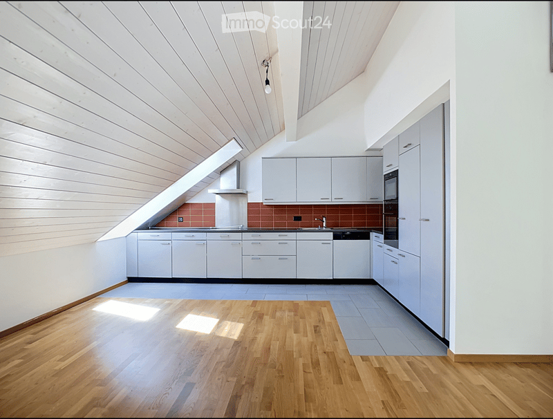 Modern kitchen with white cabinets, wooden floor, and stainless steel appliances. Features a range hood, sink, and faucet.