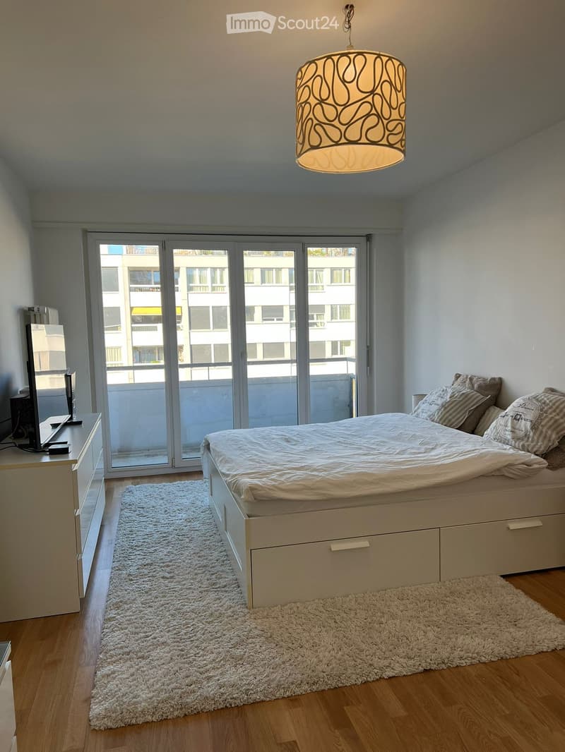 Bedroom with bed, TV, cabinet, carpet, balcony, sliding glass doors