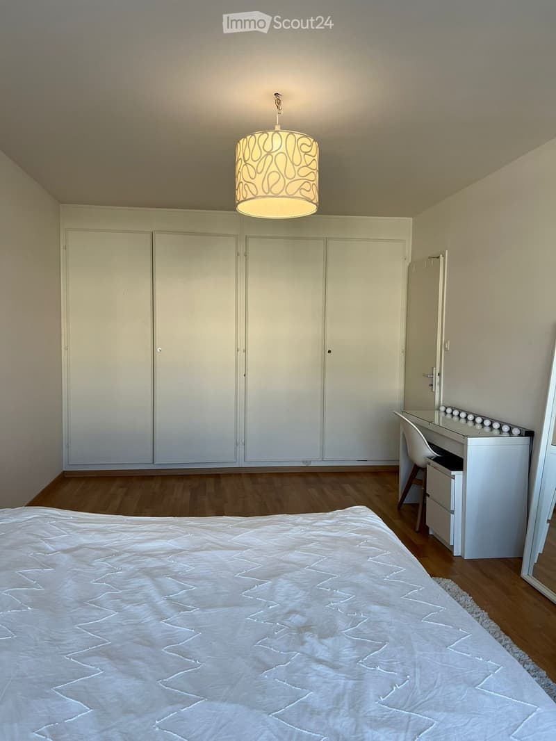 Bedroom with a bed, wardrobe, desk, and a lamp