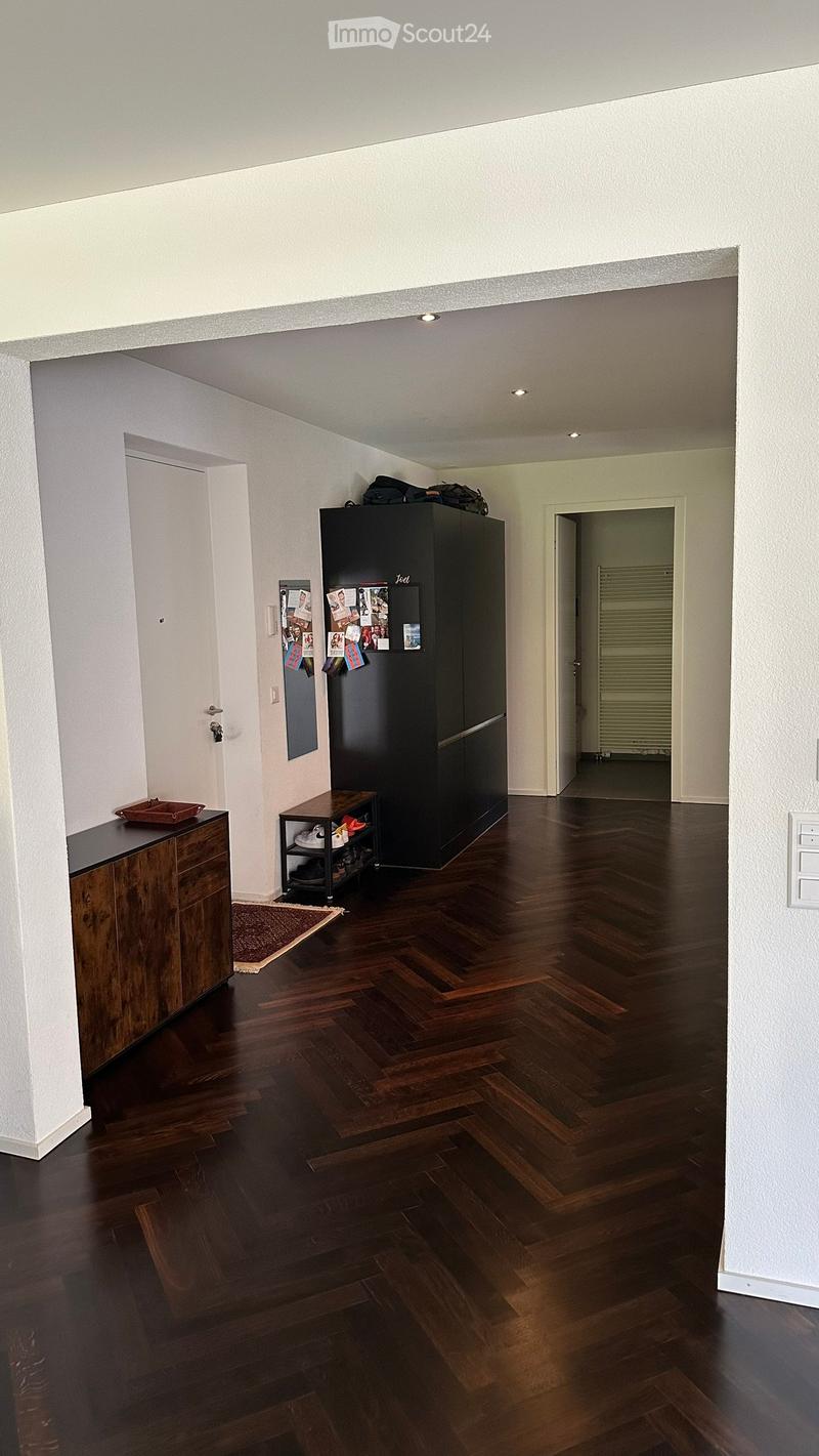 empty room, wooden floor, white walls, wooden cabinet, black wardrobe, rug, shoe rack