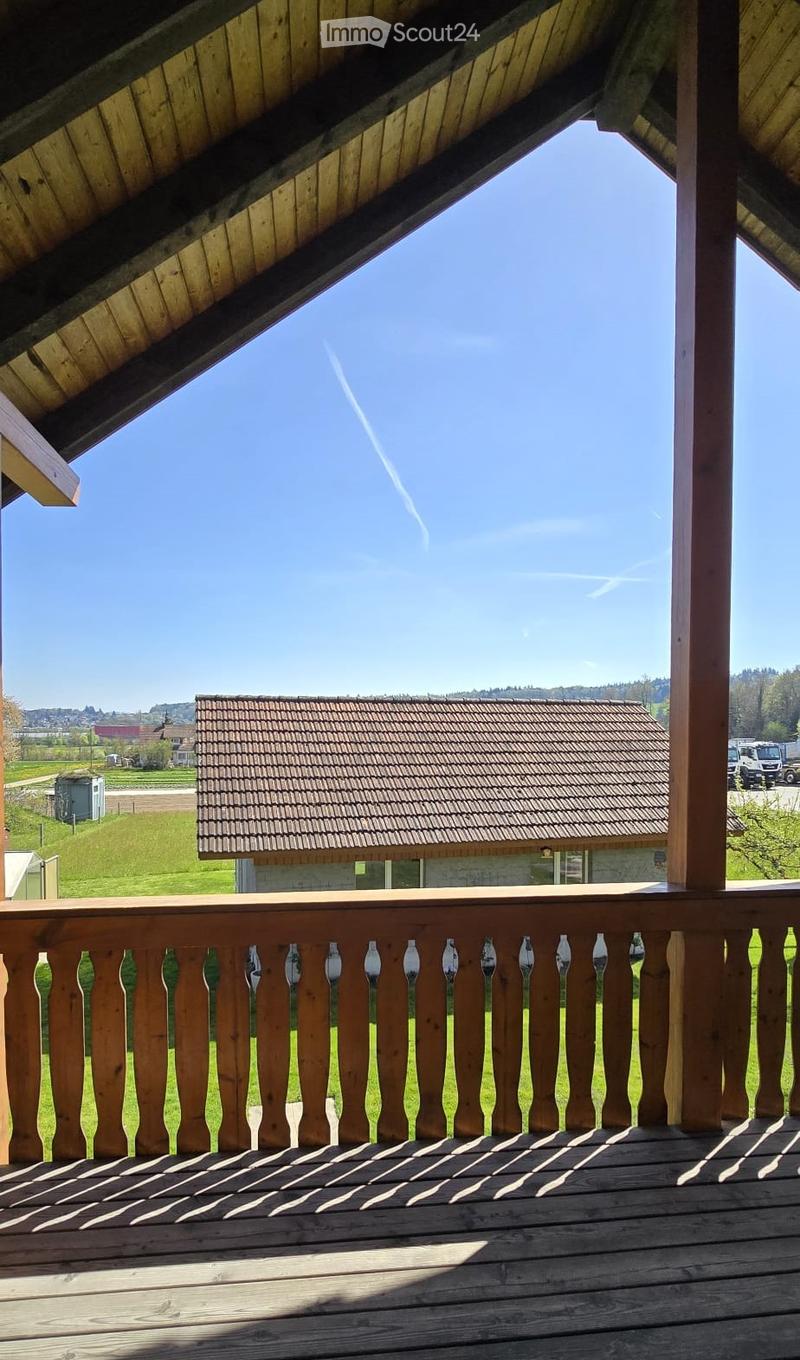 wooden balcony, wooden railing, view of a house and a field
