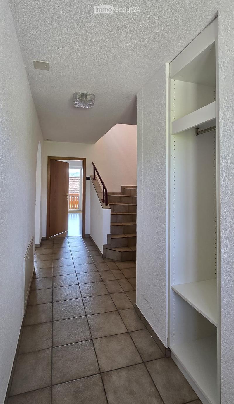 tiled floor, white walls, wooden door, staircase, radiator, wardrobe