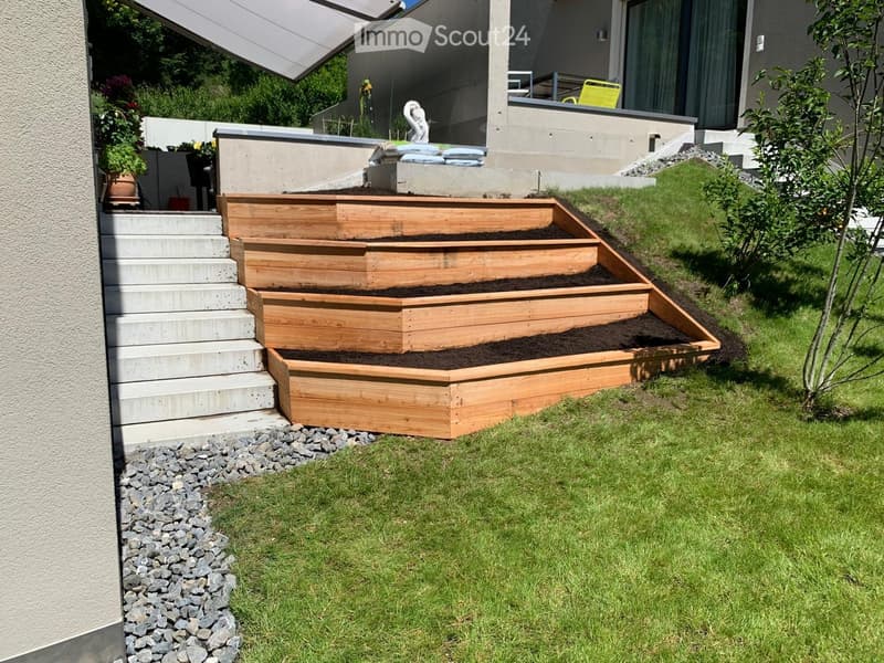 Garden / Outdoor Area. Garden with wooden raised beds, concrete steps, and a small grassy area.