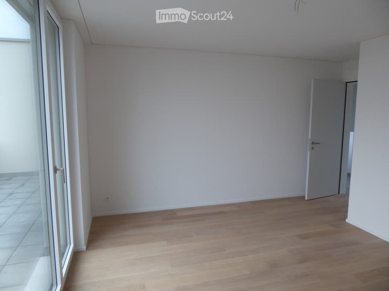 Unfurnished Room. Empty room with light wooden flooring, white walls, and a large glass door leading to a tiled area.