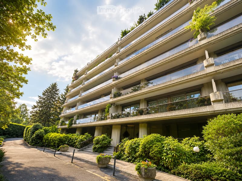 Multi-story apartment building with balconies, surrounded by greenery and a paved pathway.